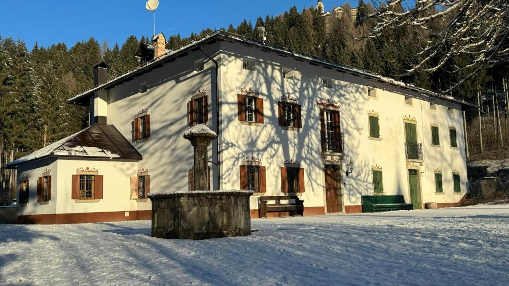 a large white building with snow in front of it at Casa Vettori in San Niccolò Comèlico
