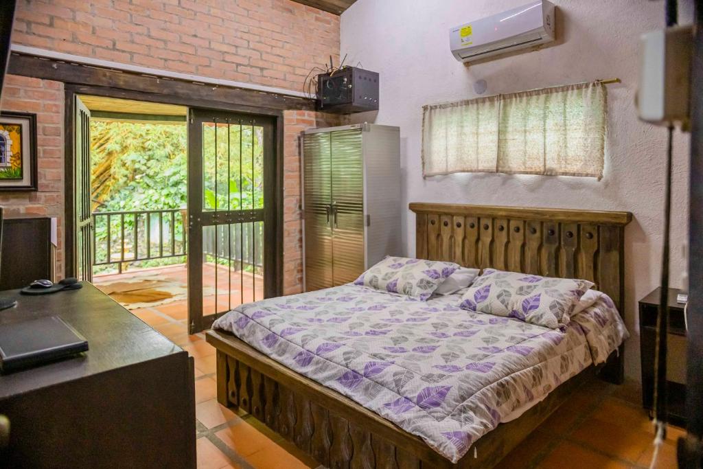 1 dormitorio con cama y escritorio. en Las Margaritas - La Tigrera, Minca, en Santa Marta
