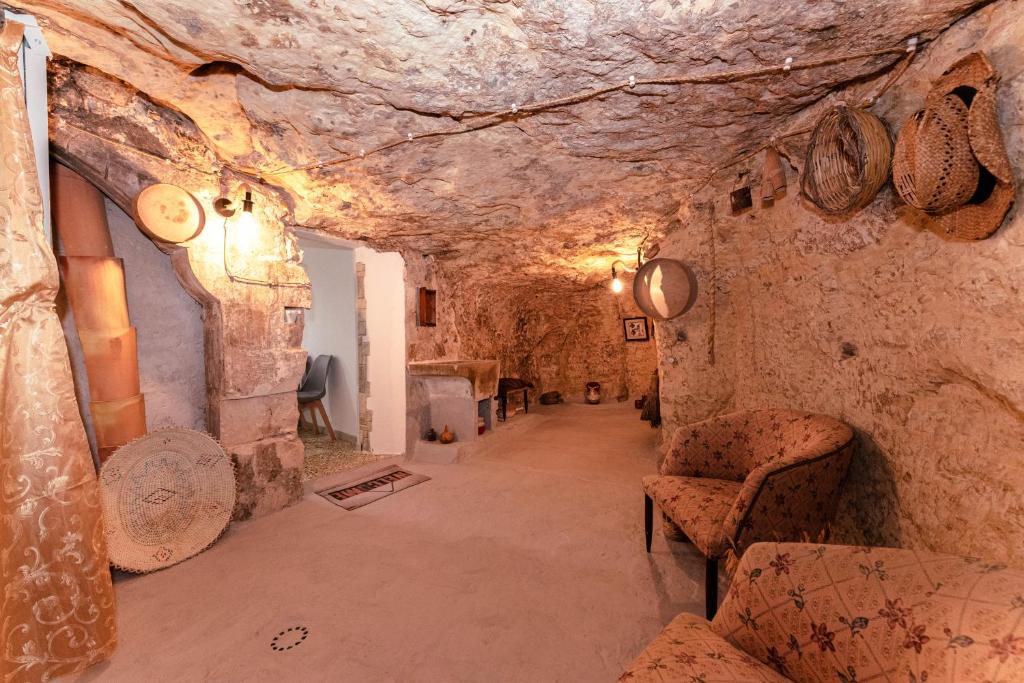 Zimmer mit Sofa und Stühlen in einer Höhle in der Unterkunft Casa vacanze San Matteo in Scicli