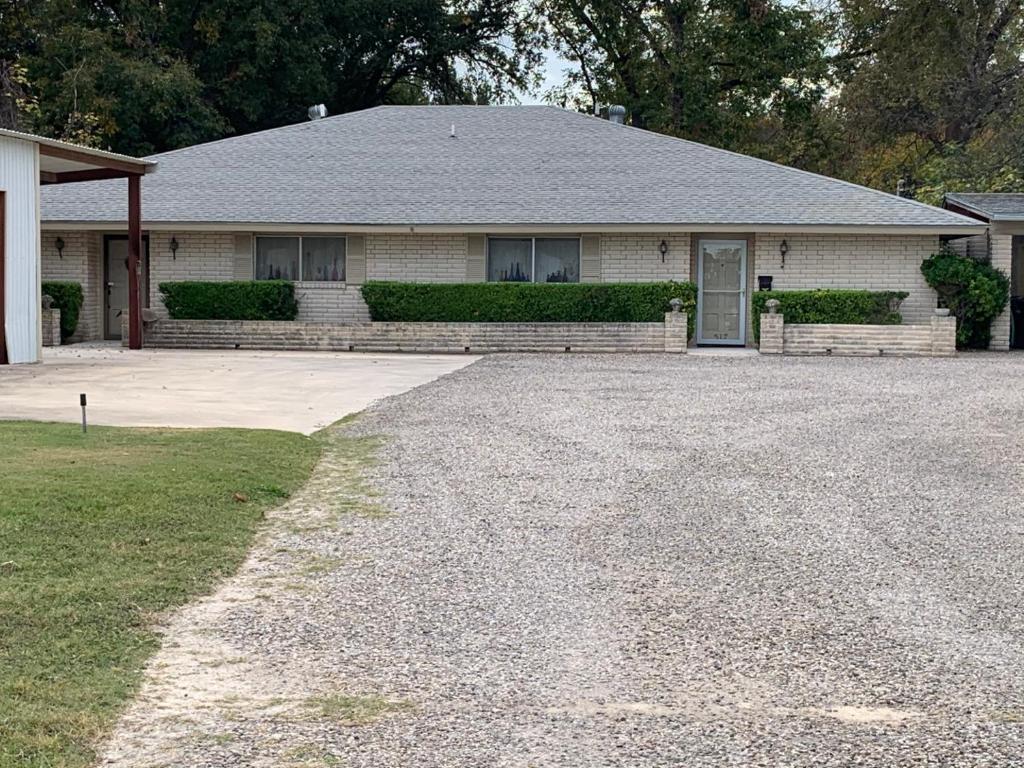 a house with a gravel driveway in front of it at Stay near Beautiful San Felipe Creek. in Del Rio