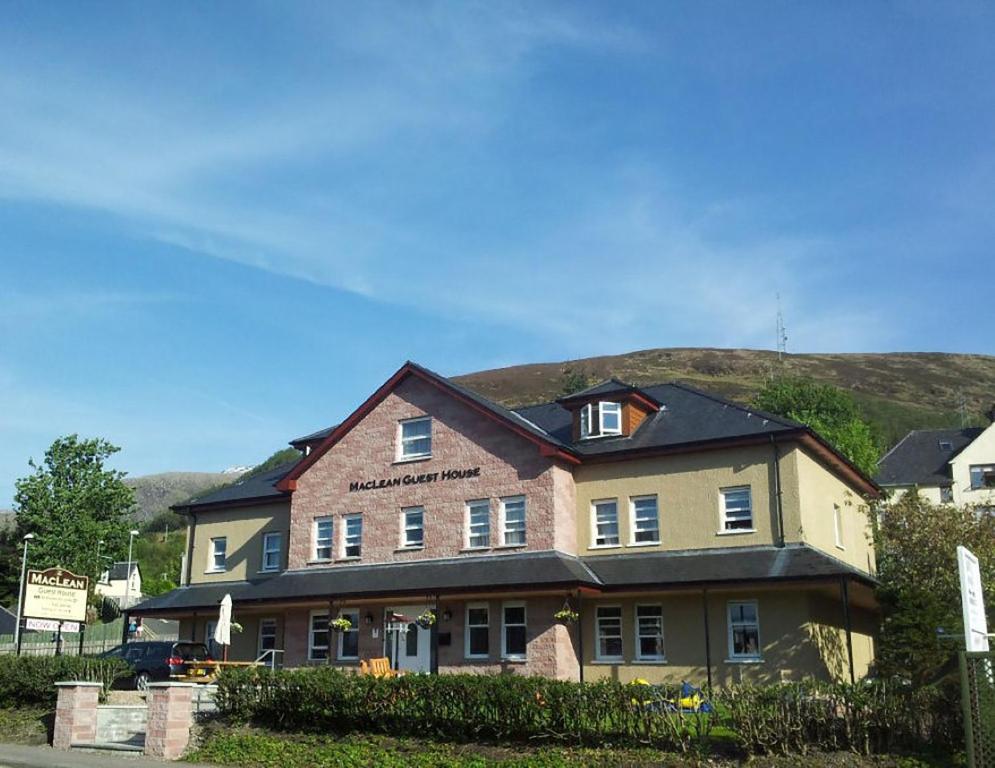 a large house with a mountain in the background at MacLean Guest House in Fort William