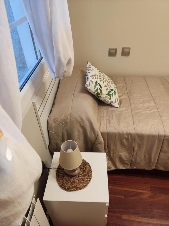 a room with a bed and a table with a hat on it at Grupo Arcanos Las Palmeras in Caldas de Reis