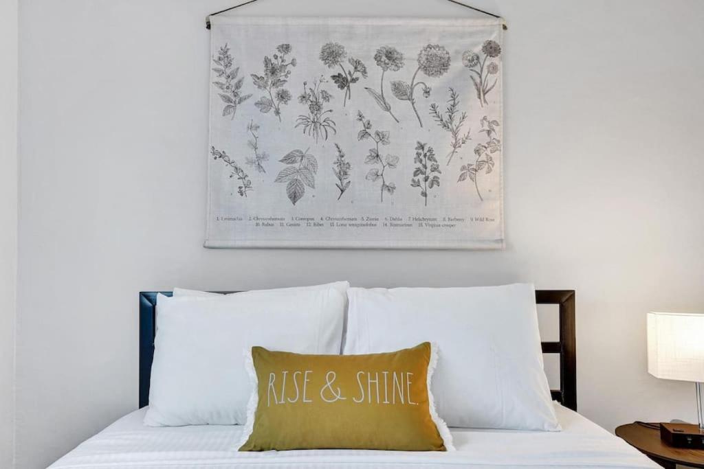 a painting above a bed with a pillow on it at Rustic Retreats Beachy 1BR for 4 guests in the heart of Fort Lauderdale in Fort Lauderdale