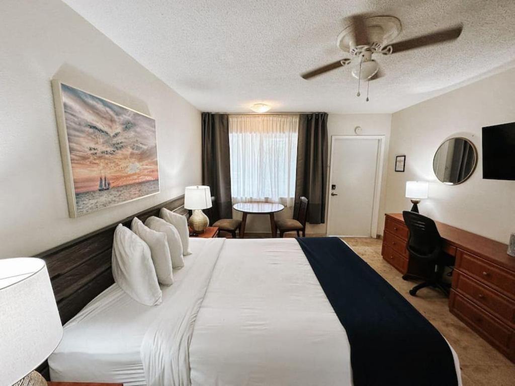 1 dormitorio con 1 cama grande y ventilador de techo en Waves Beach Town Cozy Studio Apartment, en Pompano Beach
