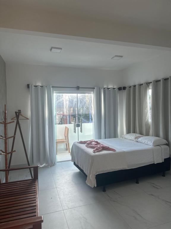 - une chambre avec un lit et une grande fenêtre dans l'établissement Suítes Modernas no Centro da Praia da Pipa, à Pipa