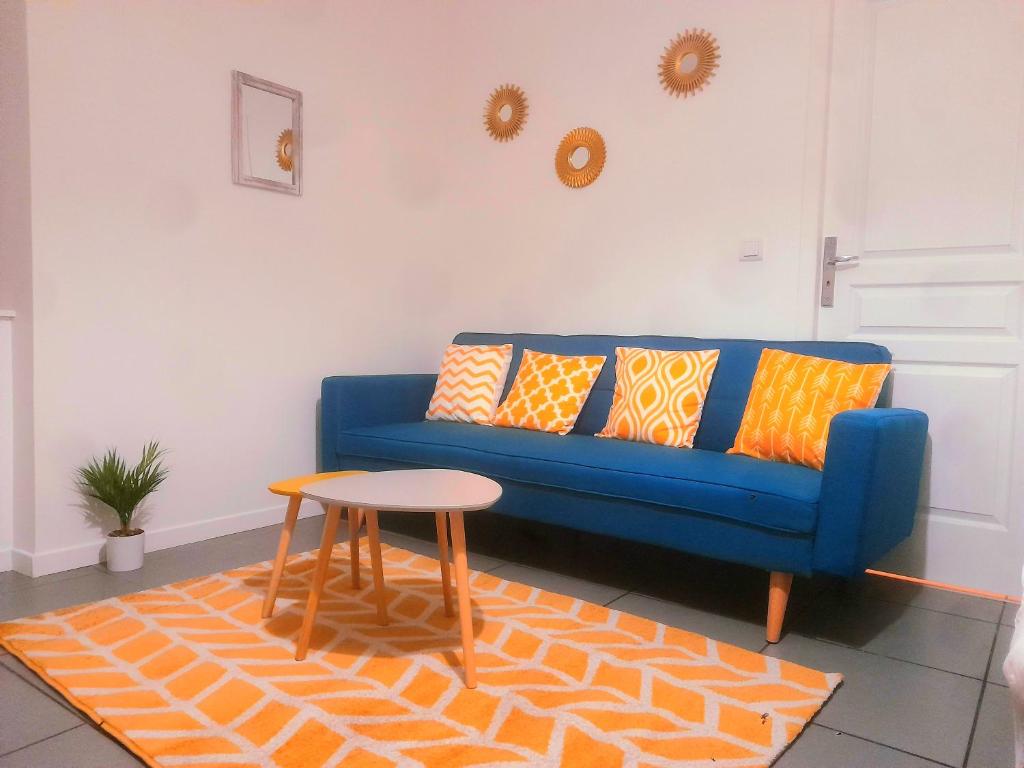 niebieską kanapę w salonie ze stołem w obiekcie Le Fjørd - Appartement confort, rez-de-chaussée, scandinave, parking gratuit w mieście Bourges