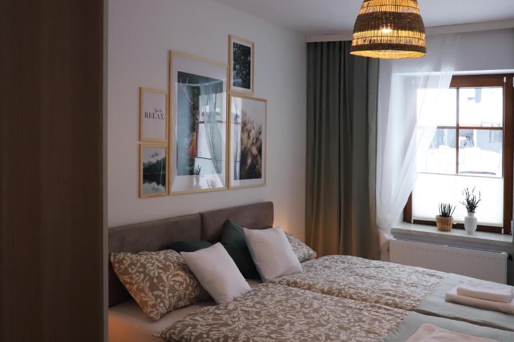 a bedroom with a bed with pillows and a window at APARTAMENT Pod Lasem Jedlina Zdrój in Jedlina-Zdrój