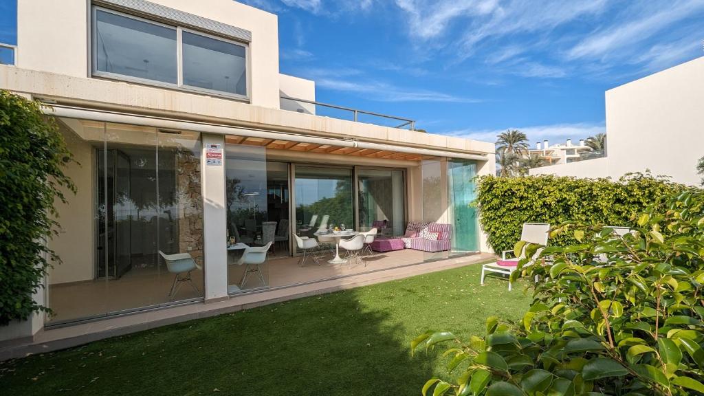 uma casa com um pátio com cadeiras e mesas em PARADISE beachfront luxury villa em Villajoyosa
