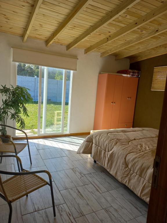 a bedroom with a bed and a large window at Casa Zona Barrio Los Acantilados para alquiler temporario in Mar del Plata
