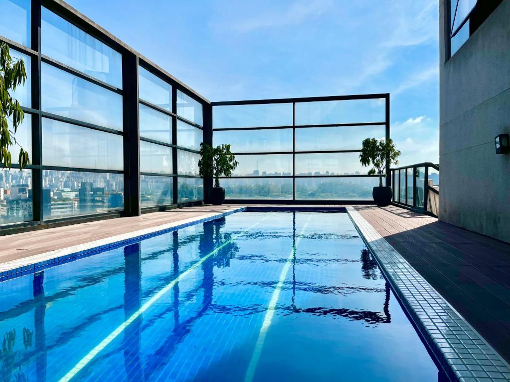 a swimming pool with a view of a building at Flat duplex com serviço de camareira e enxoval completo - ao lado do parque Ibirapuera in Sao Paulo