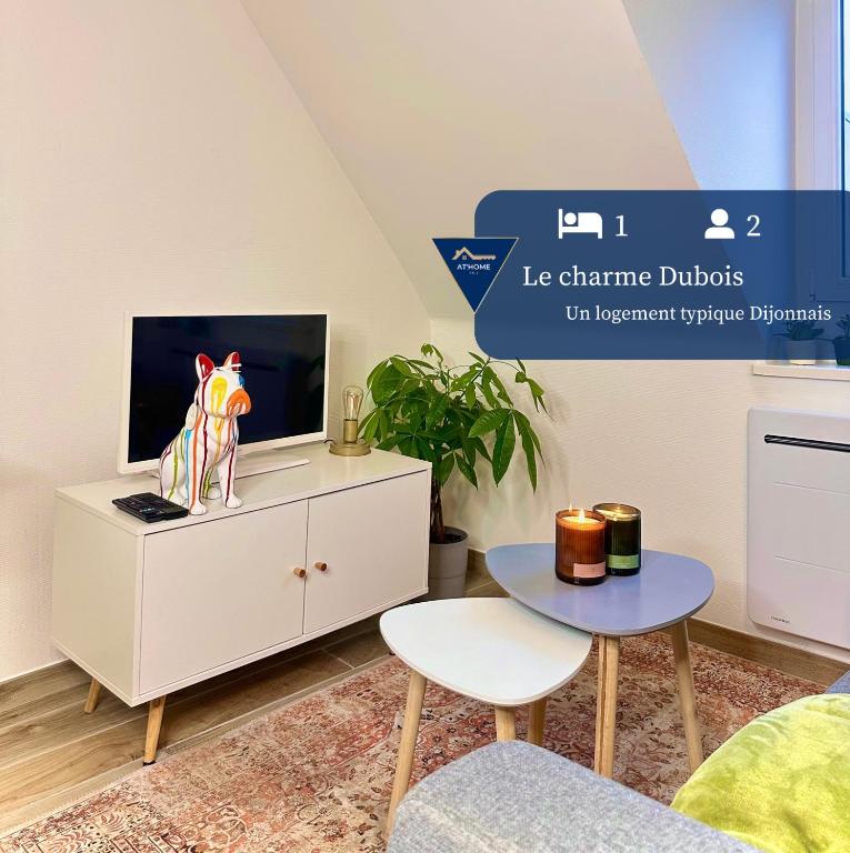 un salon avec une télévision et un meuble blanc dans l'établissement Le charme Dubois, à Dijon