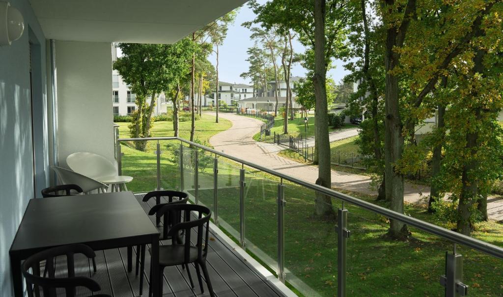 a balcony with a table and chairs and a view of a street at Apartment "Haff Ahoi" - Haffresidenz in Garz-Usedom