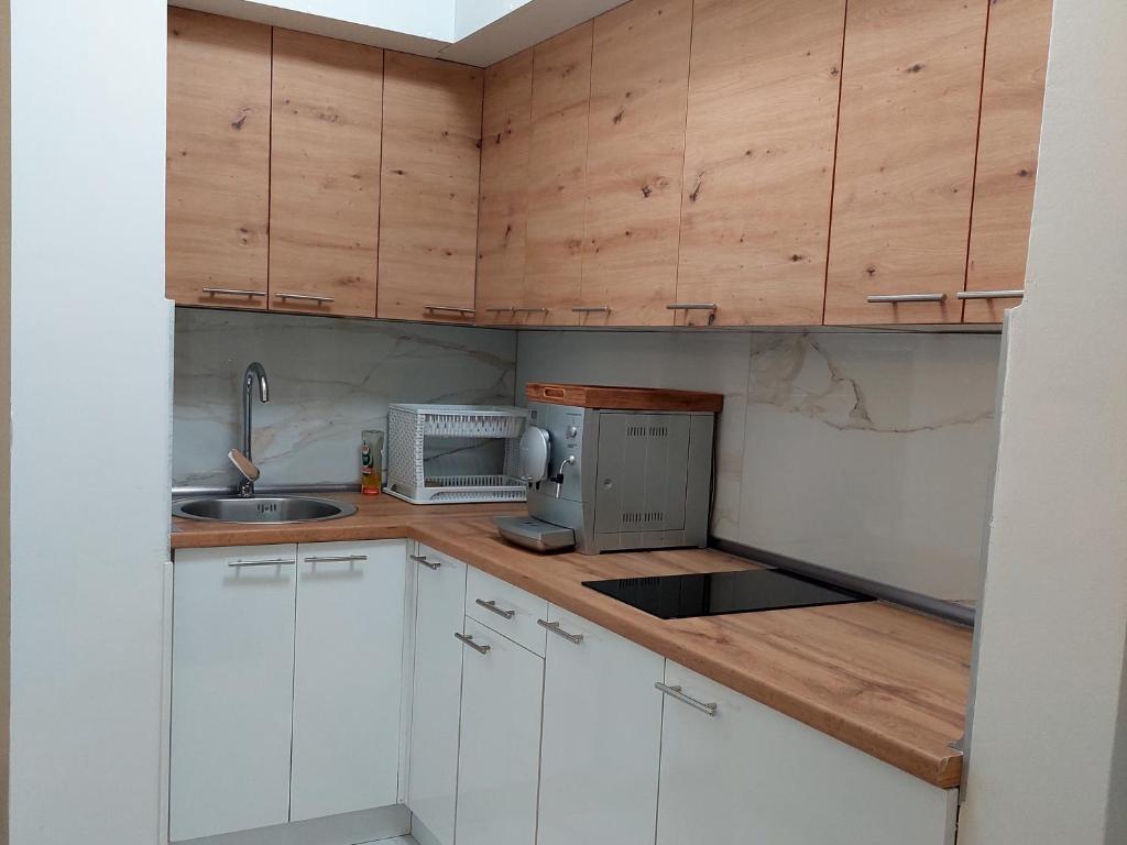 a small kitchen with white cabinets and a sink at Apartment BN MAGIC in Bijeljina