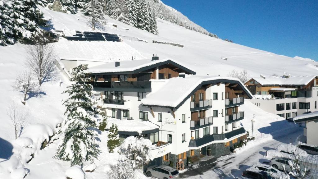 a hotel in the snow with snow covered trees at Appartements Kardona in Ischgl