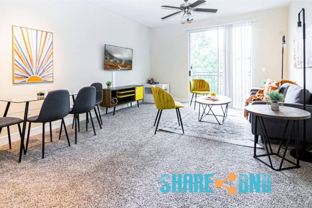a living room with chairs and a dining room at Twin Apartments-great For Groups in Dallas