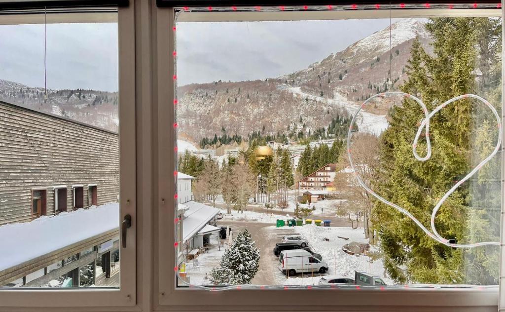 uma janela com vista para uma montanha coberta de neve em Piancavallo Panoramica em Piancavallo