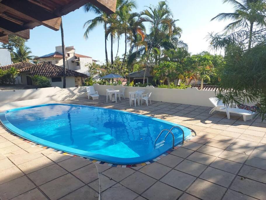 a large blue swimming pool on a patio at Casa Espaçosa em Arraial D”Ajuda in Porto Seguro