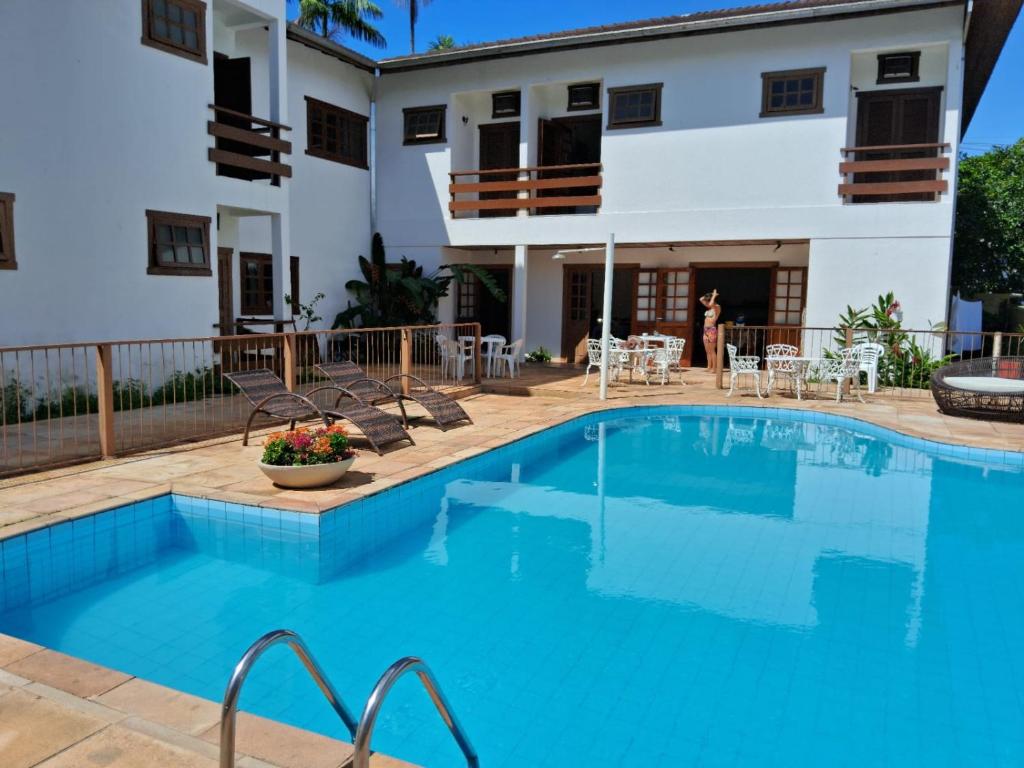 - une piscine en face d'une maison dans l'établissement Pousada Sol da Lagoinha, à Ubatuba