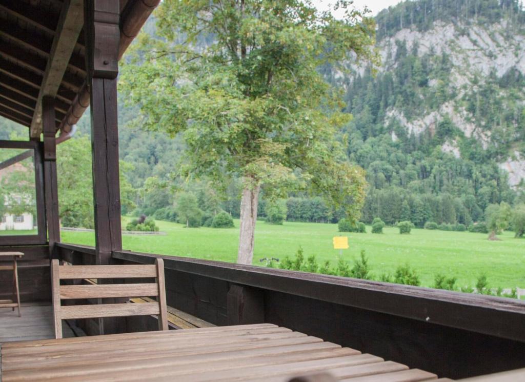 a porch with a table and a view of a field at Haus Oberwössen in Unterwössen
