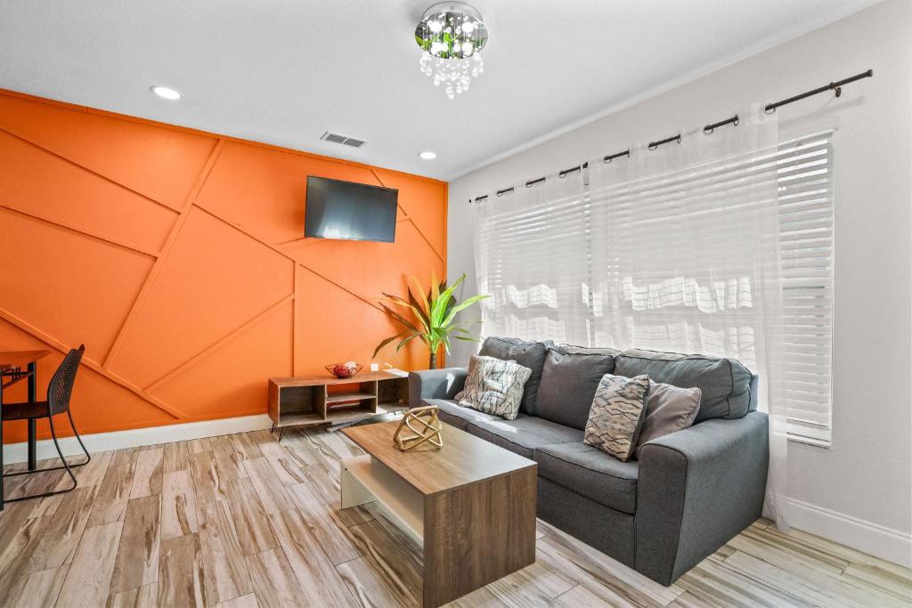 a living room with a couch and an orange wall at Bayshore Home in Tampa