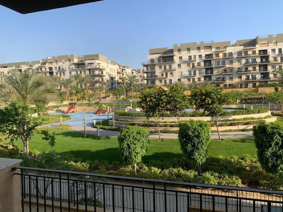 uma vista para um parque com edifícios ao fundo em Easttown Central Park apartment no Cairo