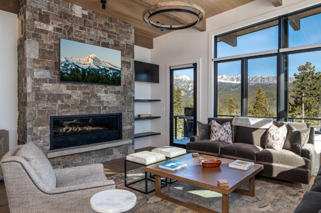 a living room with a fireplace and a stone wall at 9 Deep Forest Drive by Moonlight Basin Lodging in Big Sky