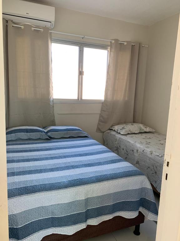 - une chambre avec 2 lits et une fenêtre dans l'établissement Apartamento Temporada Mobiliado Proximo a Praia, à Vila Velha