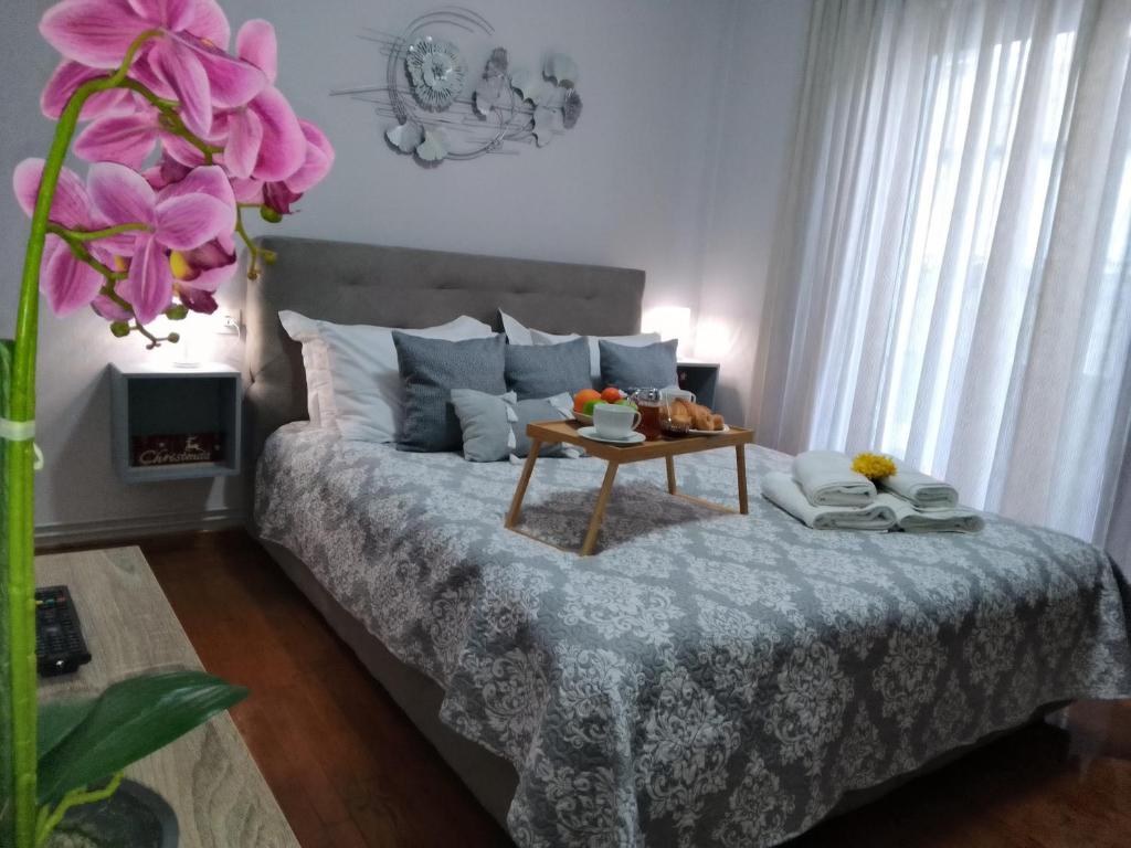 a bedroom with a bed with a table on it at Volos Hospitality, Central Apartment in Volos