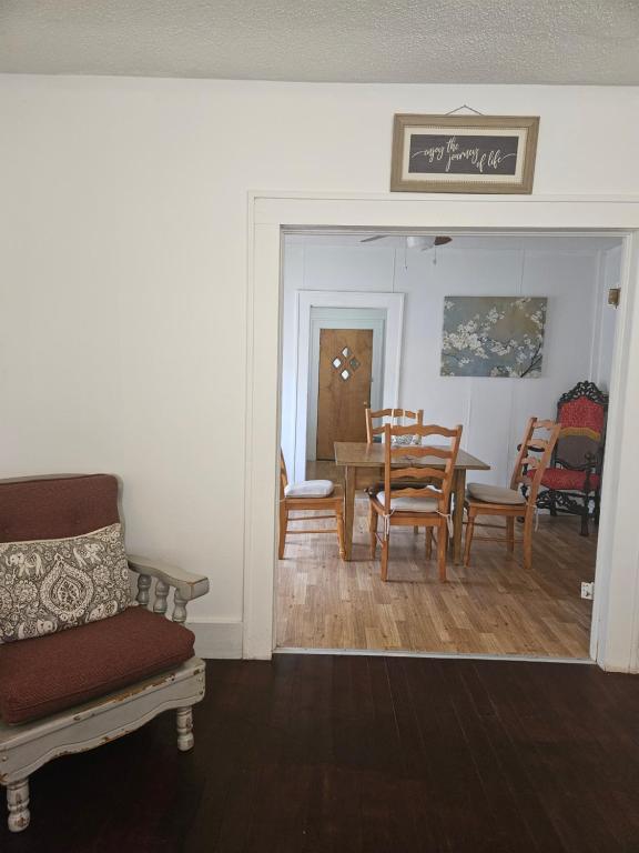 The Bungalow في Seymour: غرفة معيشة مع طاولة طعام وكراسي