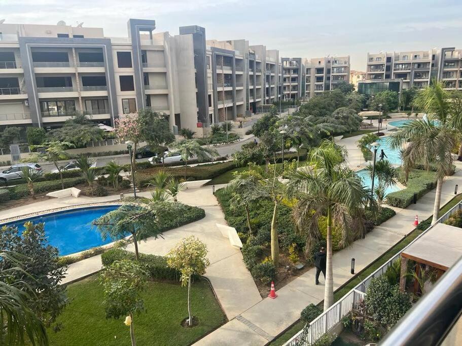 a view of a resort with a pool and buildings at Serene City Stay next to the AUC, New Cairo in Cairo