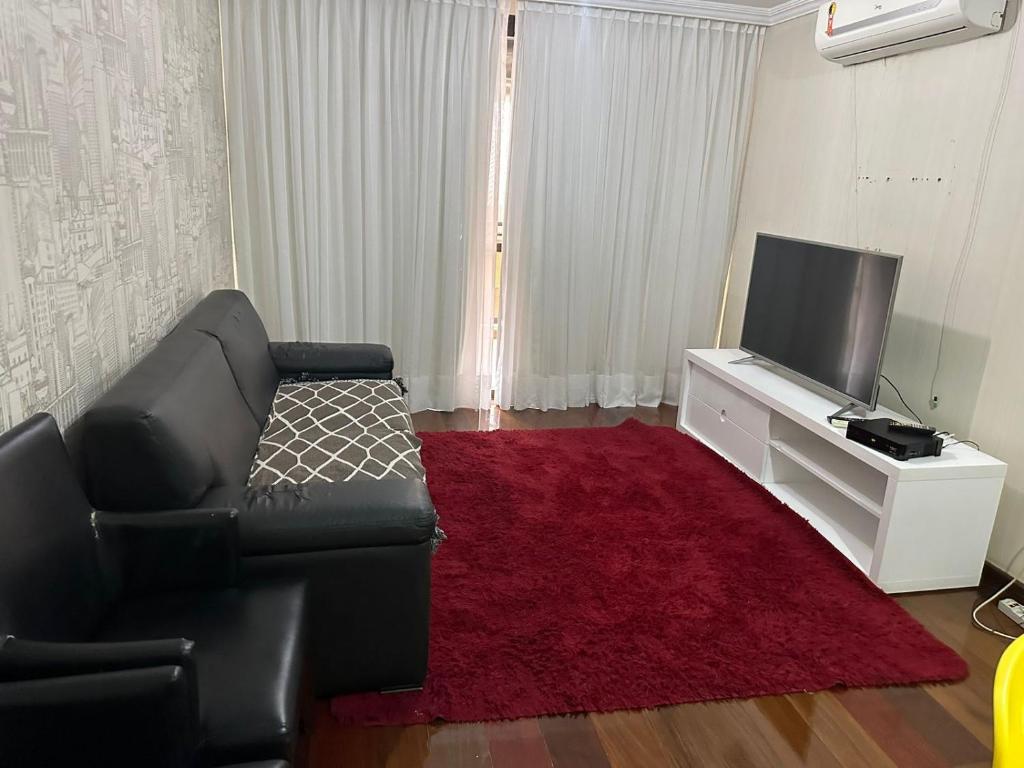 a living room with a couch and a flat screen tv at Ed Vila de Ofir 200m da Praia in Rio de Janeiro