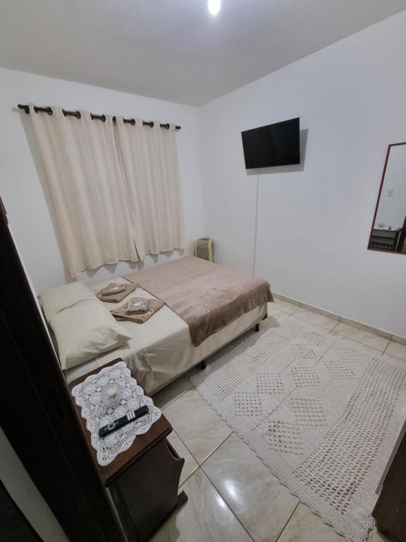 a bedroom with a bed and a flat screen tv at Studio Ideal in São Paulo