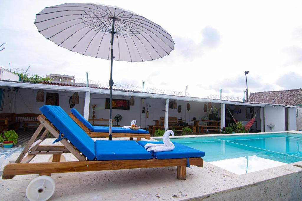 a pool with two lounge chairs and an umbrella at CASA PLAYA JAMES in Los Arrayanes