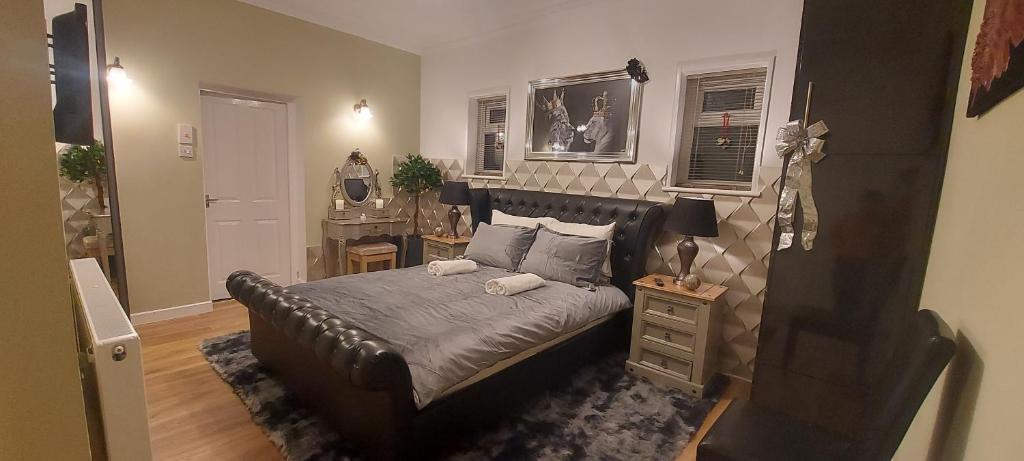 a bedroom with a leather bed and a night stand at OLIVE TREE - 2 Master bedroom (sleeps 6) in Blackpool