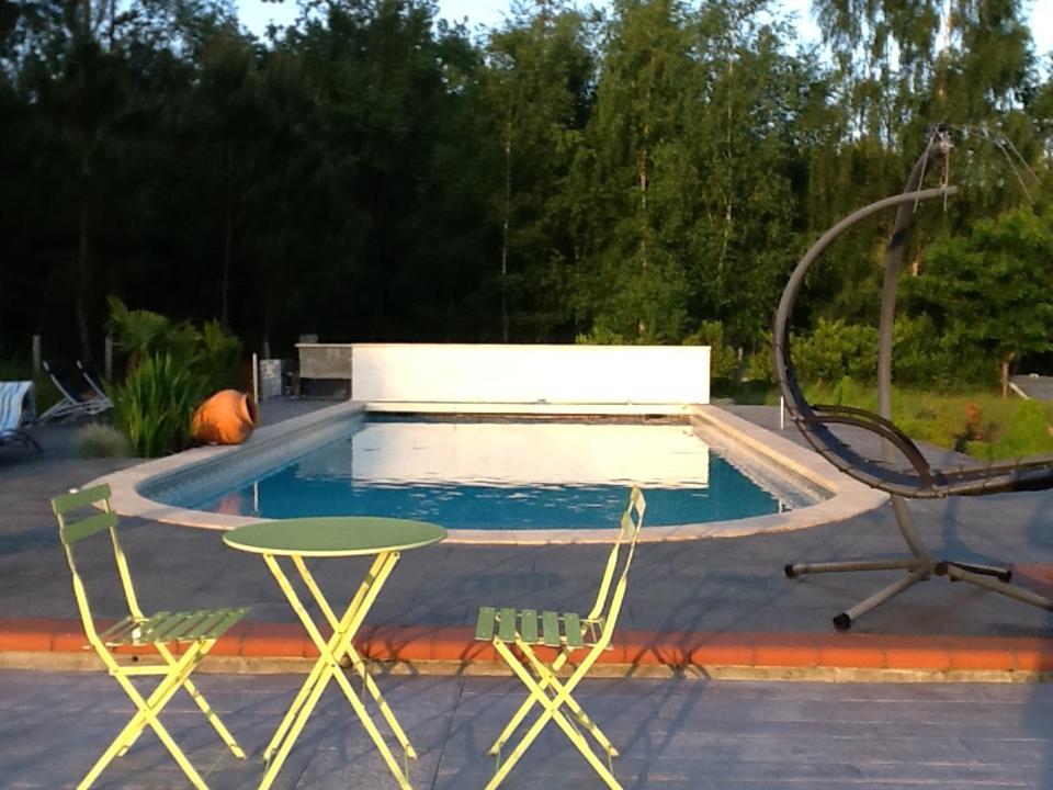 - une piscine avec 2 chaises, une table, une table et une chaise dans l'établissement Pascal et Domi 