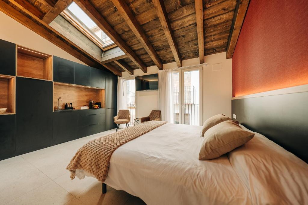 ein Schlafzimmer mit einem großen Bett und einer Holzdecke in der Unterkunft Casa Pelegrí in Morella