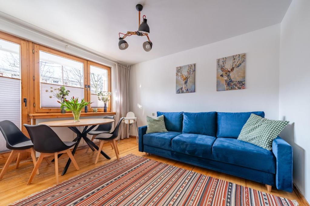 sala de estar con sofá azul y mesa en Apartament Lisowski CENTRUM, en Zakopane