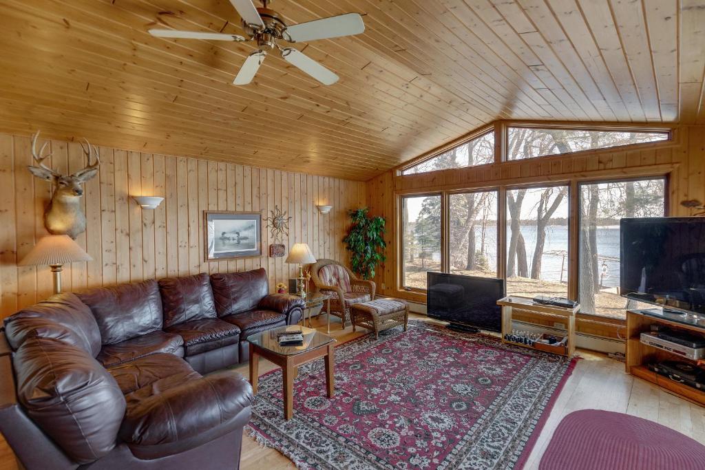 - un salon avec un canapé en cuir et une télévision dans l'établissement Two Lakefront Whitefish Chain Cabins for price of one, à Cross Lake