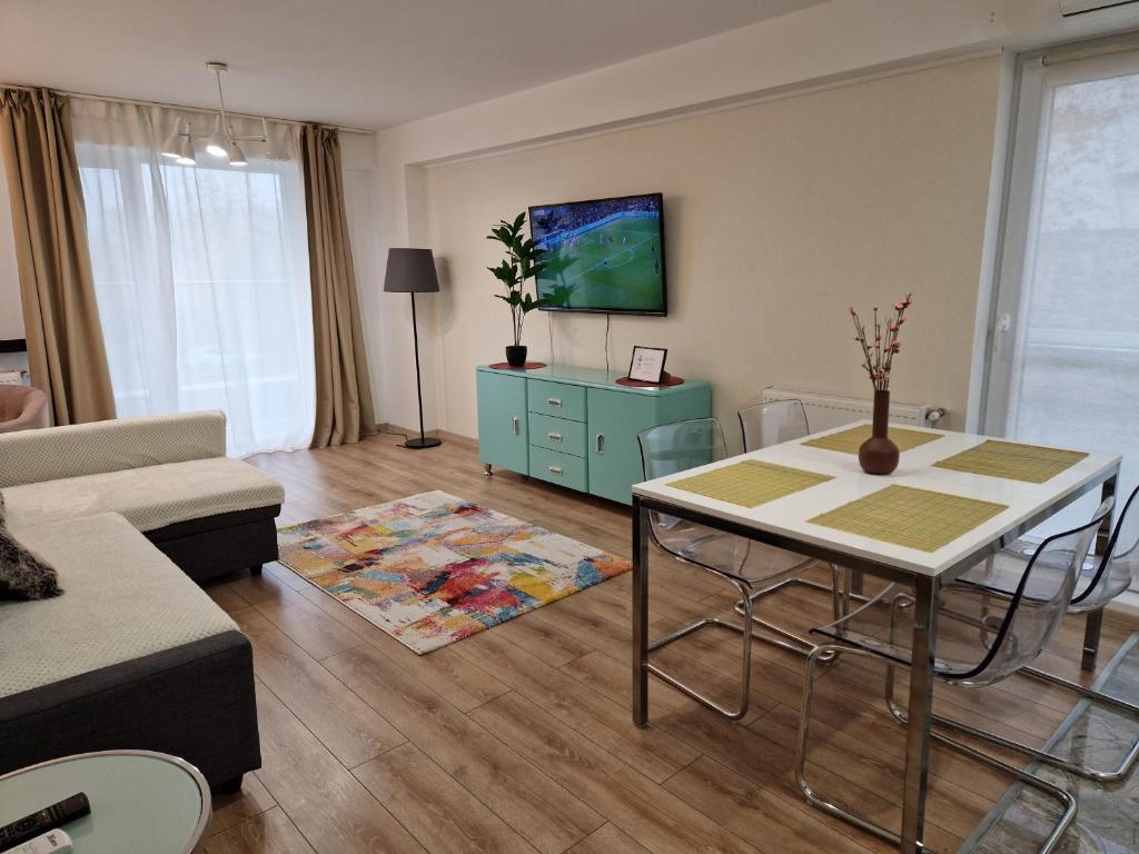 uma sala de estar com uma mesa e um armário azul em Golden Airport Residence em Otopeni