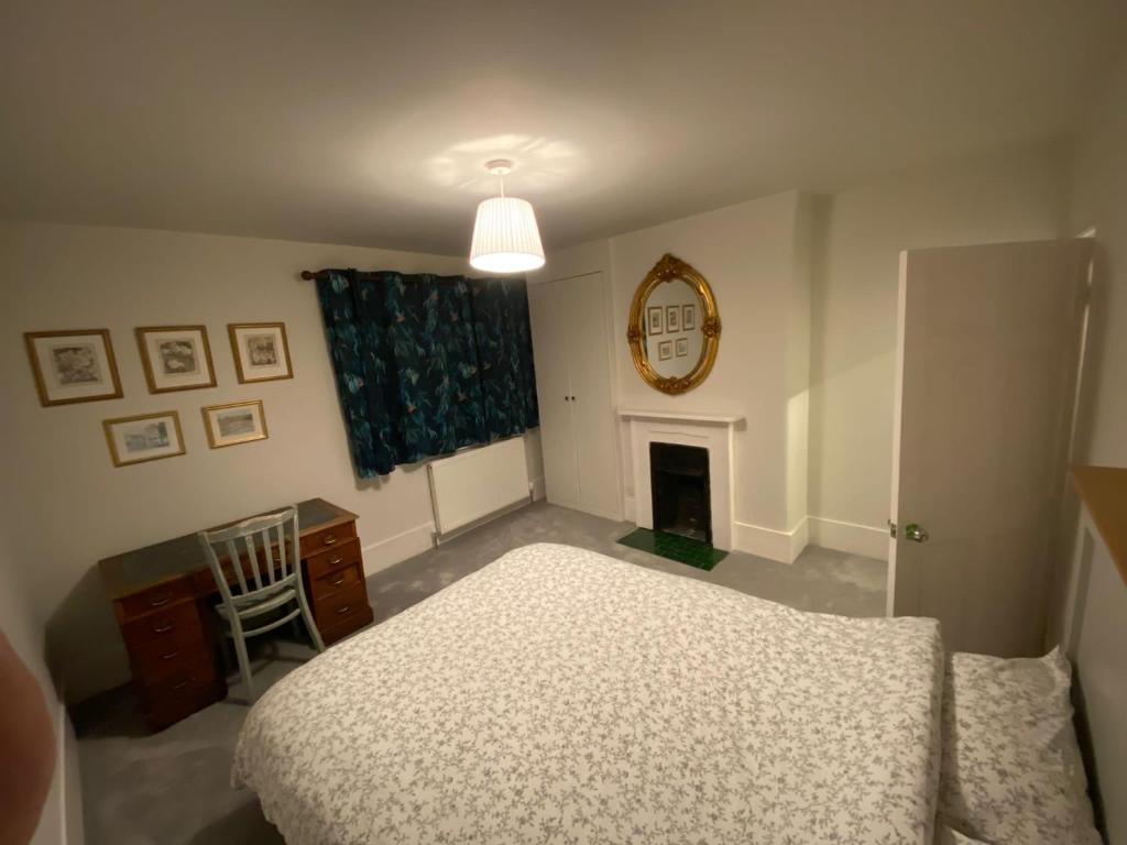 ein Schlafzimmer mit einem Bett, einem Tisch und einem Stuhl in der Unterkunft The Windsor Room With Private Bathroom in Windsor