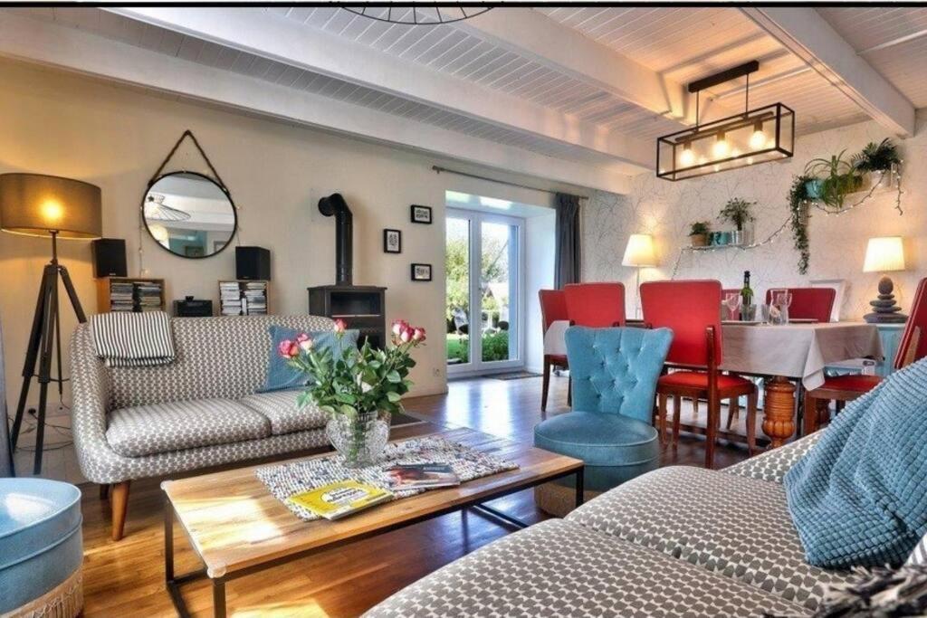 een woonkamer met een bank, stoelen en een tafel bij Maison avec Jardin,Terrasse,bar,baby foot 4-6 pers in Le Guilvinec