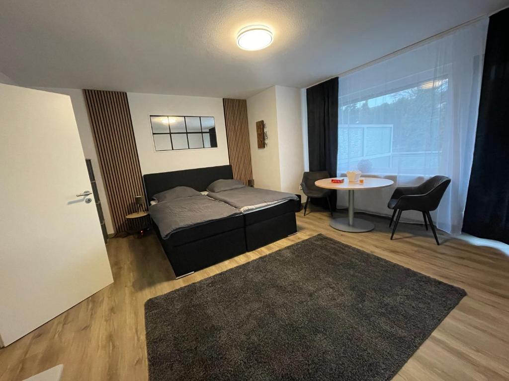 een slaapkamer met een bed en een tafel in een kamer bij Gemütliche und entspannte Stadtoase in Krefeld Zentrum, Deluxe Living, 50qm nähe Düsseldorf Messe, Netflix und IpTv in Krefeld