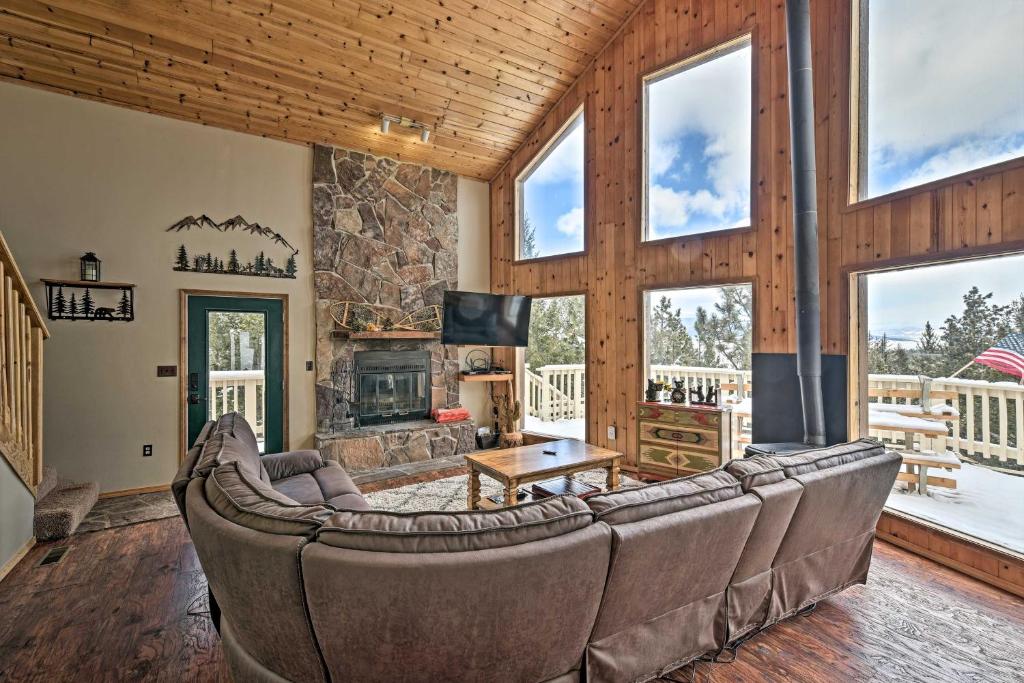 a living room with a couch and a fireplace at Spacious Mountain-View Cabin By Angel Fire Resort in Angel Fire