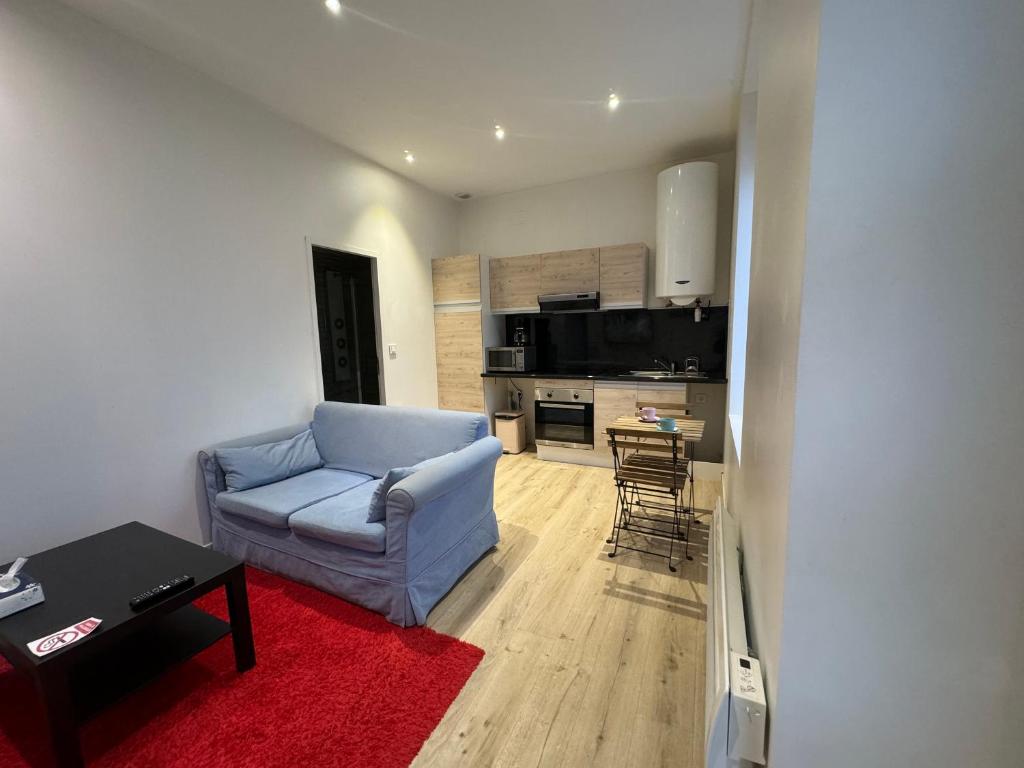 sala de estar con sofá azul y cocina en Eliya, en Romilly-sur-Seine