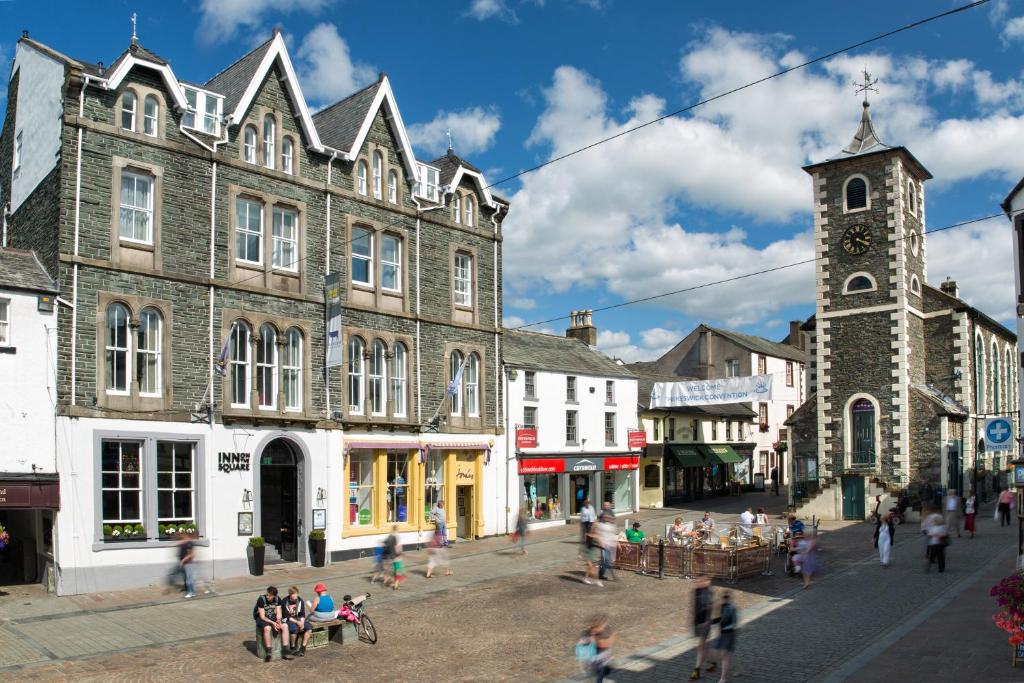 a group of people walking on a street in a town at Inn on the Square in Keswick