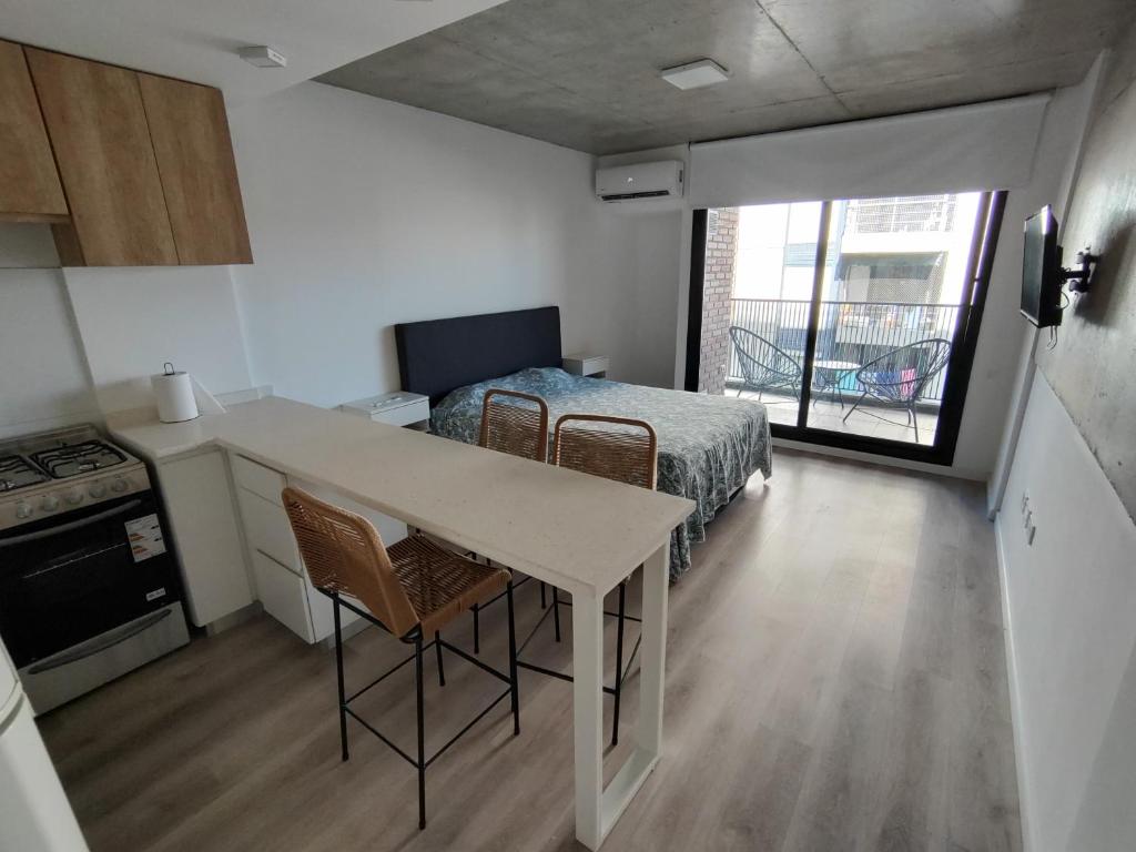 Habitación con cama y cocina con mesa en Monoambiente céntrico a estrenar en Rosario