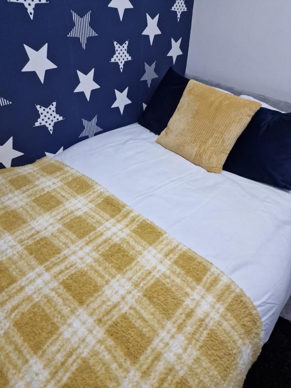 a bed with a plaid blanket on top of it at Cosy and Unique Bedroom In Gateshead in Sheriff Hill