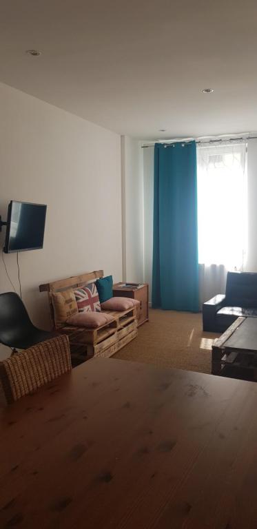 un salon avec un canapé et une fenêtre dans l'établissement Centre ville le Puy-en-Velay au 1er étage, au Puy-en-Velay