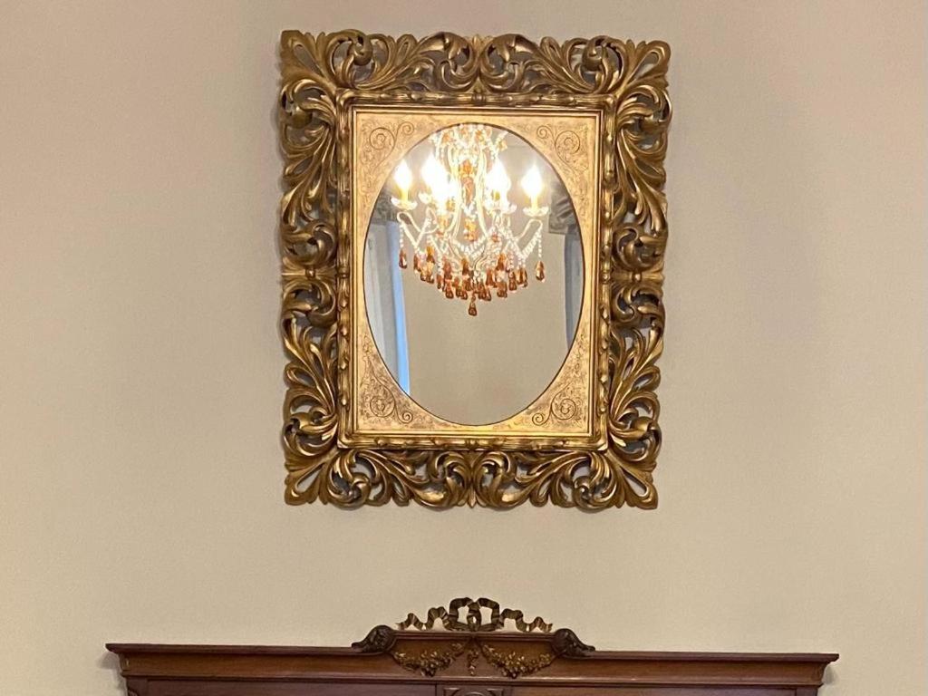 einen goldenen Spiegel an einer Wand mit einem Kronleuchter in der Unterkunft Stadtpalais Königssuite maximal 2 Personen und 1 Kleinkind in Bautzen
