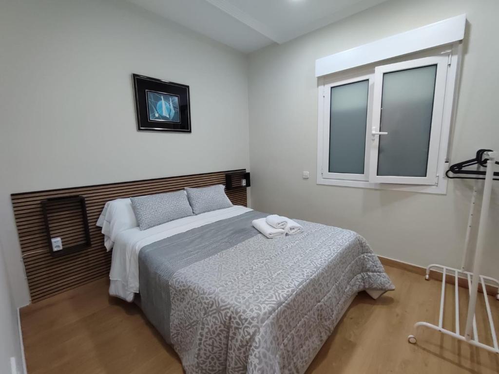 1 dormitorio con 2 camas y ventana en Apartamento en Gran Vía, en Bilbao